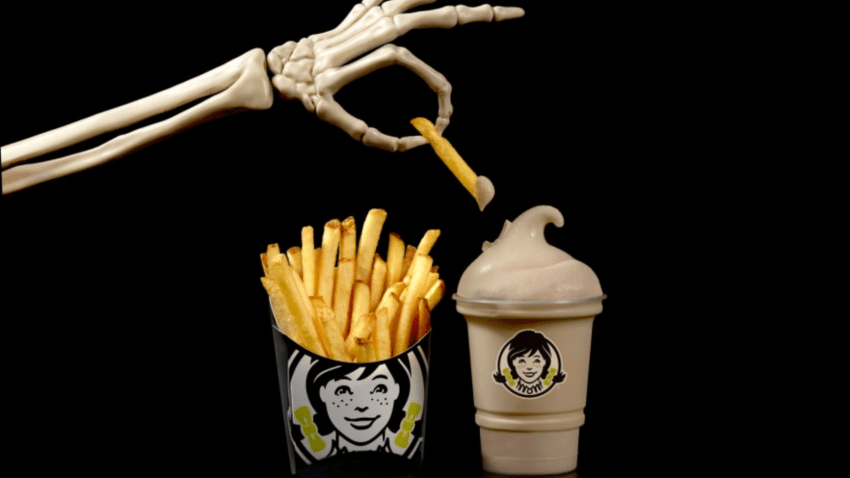 A skeleton hand dips a fry into a Wendy's frosty.